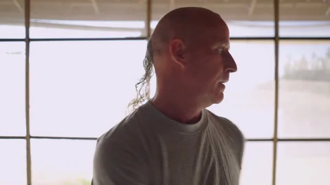 Close up of male Qigong instructor making trunk exercises and speaking. Strong Video stock 217438570