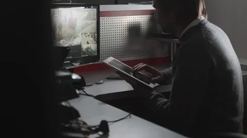 Close-up Of Male Security Guard with tablet pc While Monitoring Multiple CCTV Stock Footage 72684136