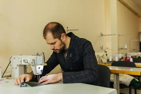 Close up of a male shoemaker working with leather textile at his workshop Stock Photos