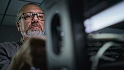 Close up of male system administrator setting up network equipment using tablet 写真素材