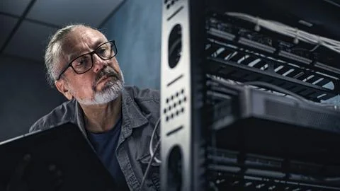 Close up of male system administrator setting up network equipment using tablet 写真素材