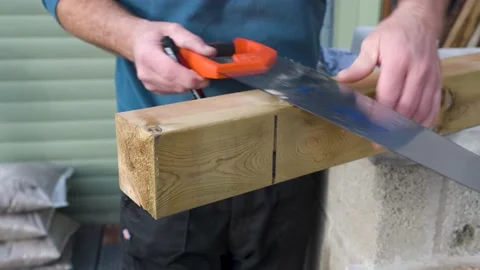 Close up of male using a hand saw to mark out hand rail post ready to be cut Video stock 142707043