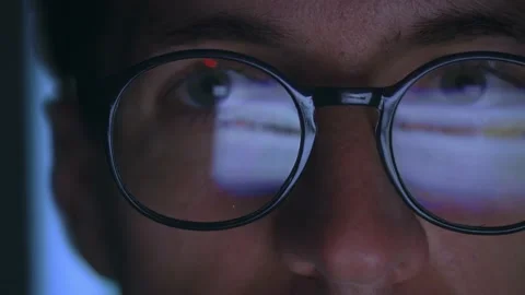 Close up male working at computer late at night, reflection in glasses of laptop Stock Footage 230423729