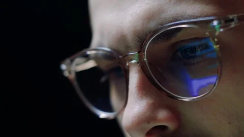 Close up male working at computer late at night, reflection in glasses of laptop Stock Footage 263546339