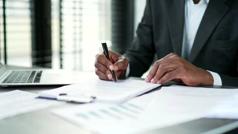 Close up of a male's hand signing documents at desk at a workplace in a business Stock Footage 300195765