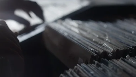 Close-up of male's hands sifting through a row of vinyl music records Stock Footage 122597518