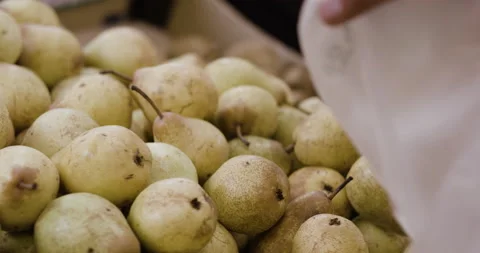 Close up of Mama Celeste picking up fresh pears into bag from fresh market Stock Footage 158696619