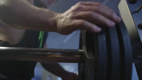 Close-up of a man adding weight to a barbell in the gym. Stock Footage 236045255