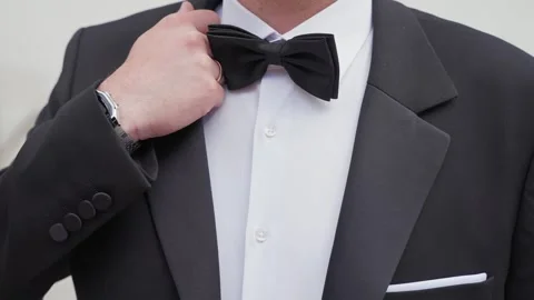 Close-Up of Man Adjusting Bow Tie in Formal Black Tuxedo for Elegant Event Vídeo Stock 336412181