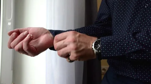 Close up of man adjusting cuff button on his stylish dark blue Stock Footage 339093126