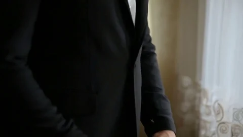 Close-up man adjusting his jacket button while standing on background Stock Footage 85192857