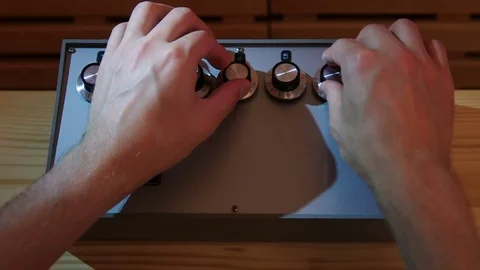Close-up on a man adjusting volume on retro mixing console with studio light Video stock 77409420