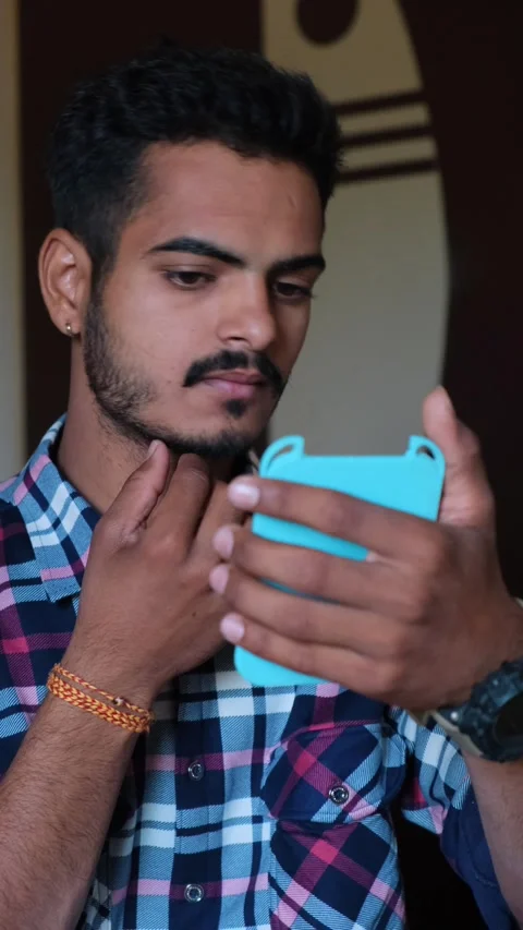 Close-up of a man admiring his face in a hand mirror, indoor Видео 331354505