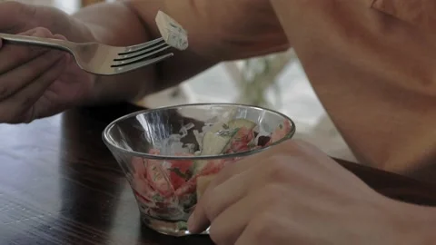 Close-up of a man with an appetite eating a vegetable salad from a small glass Stock Footage 161813521