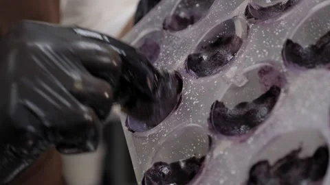 Close-up of a man applies the dye to the mold for sweets or pralines. Stock Footage 270064510