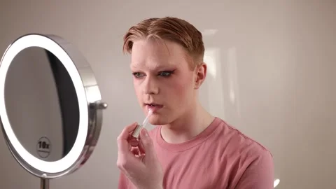 A Close-Up of a Man Applying Lip Gloss in Front of Mirror Stock Footage 310033692