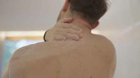 Close up of a man applying moisturizing cream to his shoulder and back Stock Footage 335268137
