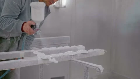 Close up man applying white paint on furniture detail pieces using varnish gun. Stock Footage 296541422