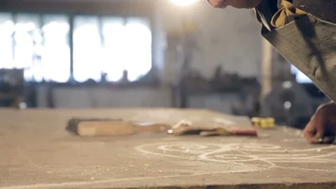 Close-up man in apron blows dust from the table Stockbeeldmateriaal 76392202