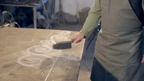Close-up man in apron sweeping dust from the table Stock Footage 77005123