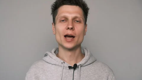 Close up of man attaching lavalier microphone to his hoody. Preparing to record Stock Footage 311570141