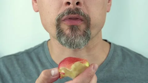 Close-up, a man with beard and moustache eating a red apple, close-up, 4K Stock Footage 145109200