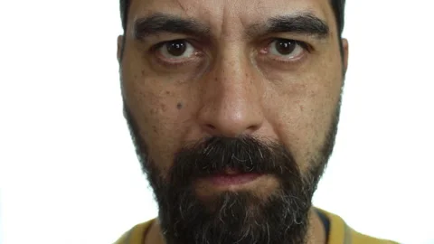 Close-up, man with beard and serious face looks straight at the camera Stock Footage 142152564