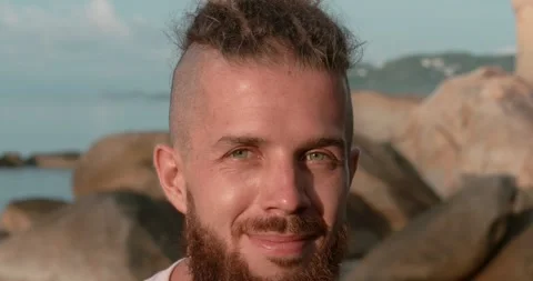 Close-up man with beard on beach during sunset sea at background Harmony in warm Stock Footage 274518529