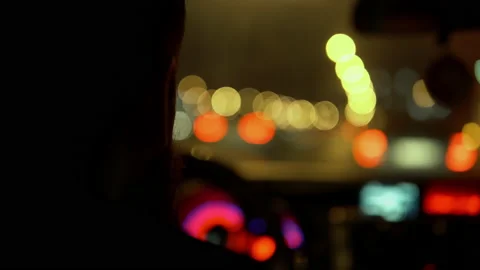Close-up of a man with a beard drives a car at night against the background of Stock Footage 147624054