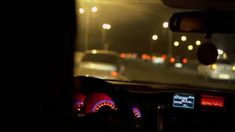 Close-up of a man with a beard drives a car at night against the background of Stock Footage 147624488
