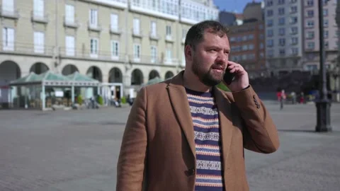 Close-up of a man with a beard talking on the phone in sunny weather in the Stock Footage 220320822