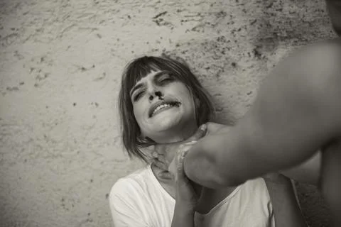 Close-up of a man from behind, hitting with a crying woman to a dirty wall. G Stock Photos