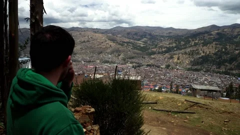 Close-up of a man from behind looking at his town in the Sierra Huaras Vidéo 164560417