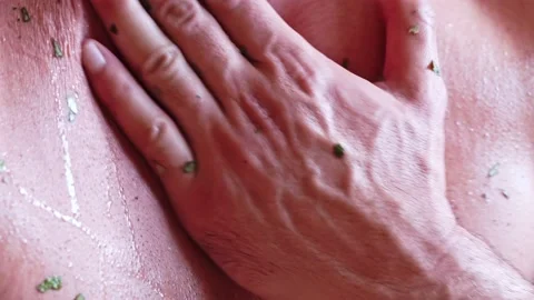 Close-up of a man being beaten on the back steamed with a juniper broom in the Stock Footage 226047538