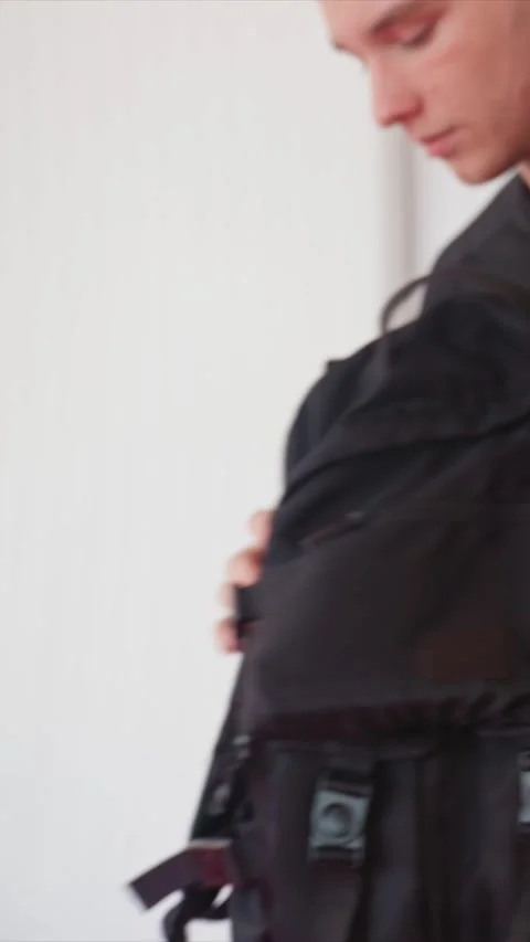 Close up of man in black adjusting backpack straps buckles zippers pockets Stock Footage 345548427