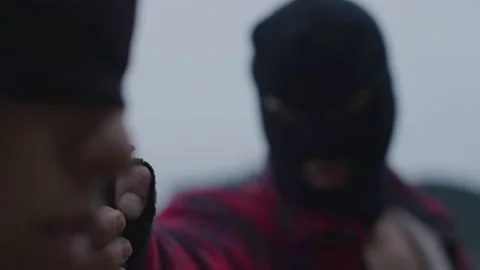 Close up of Man in Black Ski Mask Holding Gun to Blindfolded Woman's Head Stock Footage 208754523