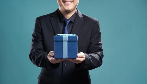 Close up of man with blue present box , isolated on light blue background . Stock Photos