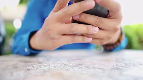 Close up of a man in a blue shirt using a smartphone Stock Footage 147956859