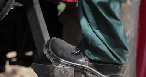 Close up of a man boots stepping into tractor tractor. Stock Footage 169913929