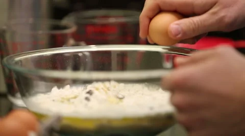 Close up of man breaking egg into mixing bowl Stock Footage 61351562