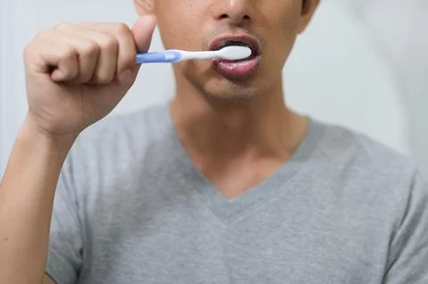 Close-Up of Man Brushing Teeth with Toothbrush and Toothpaste Stock Photos