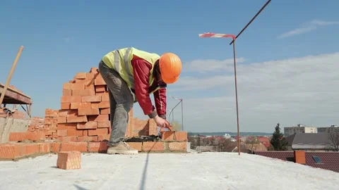 Close up of a man building a brick house. Laying red bricks on a construction Stock Footage