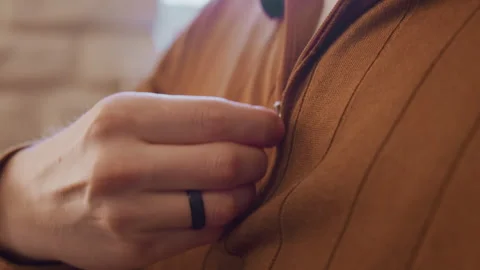 Close up man buttoning brown corduroy shirt zipper with soft light and blurred 스톡 동영상 347691312
