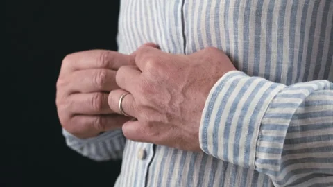 Close-up of a man buttoning his shirt 스톡 동영상 244991534
