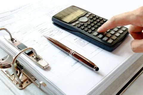Close up of man with calculator counting making notes, pen on the file fold.. Stock Photos
