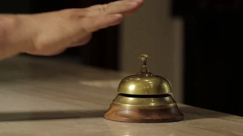 Close up. the man is calling the hotel bell. it goes to a Woman Receptionist. Stock Footage 96463601