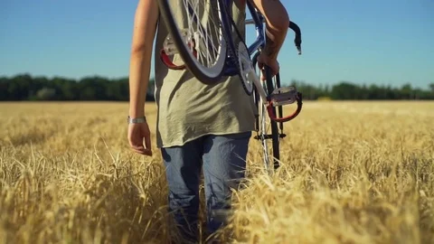 Close up man carry bicycle walk through wheat field sundown slow motion rapid Stock Footage 78041843