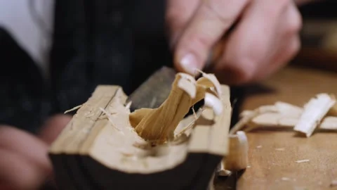 Close-up. man carves poplar tea leaves holder with chisel.the art of woodworking Stock Footage 147870826