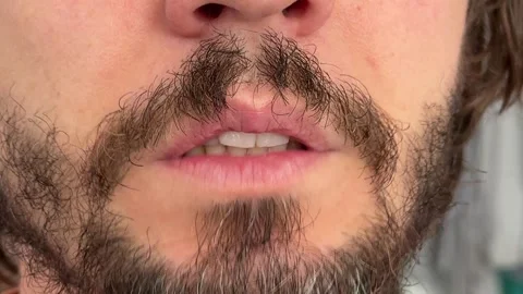 Close-up of a man chattering his teeth. Subtle jaw movement with beard and Stock Footage 336977829