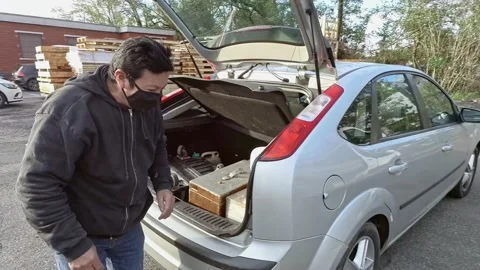 Close Up A Man Checking Stuff in His Car While Wears a Medical Mask Stock Footage 143192110